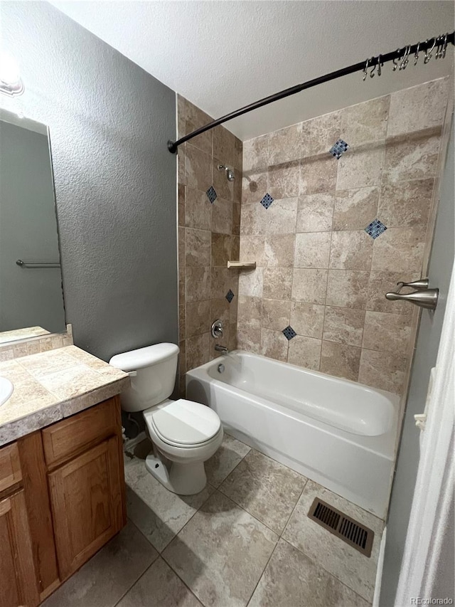 full bathroom with toilet, vanity, tiled shower / bath, and tile patterned flooring