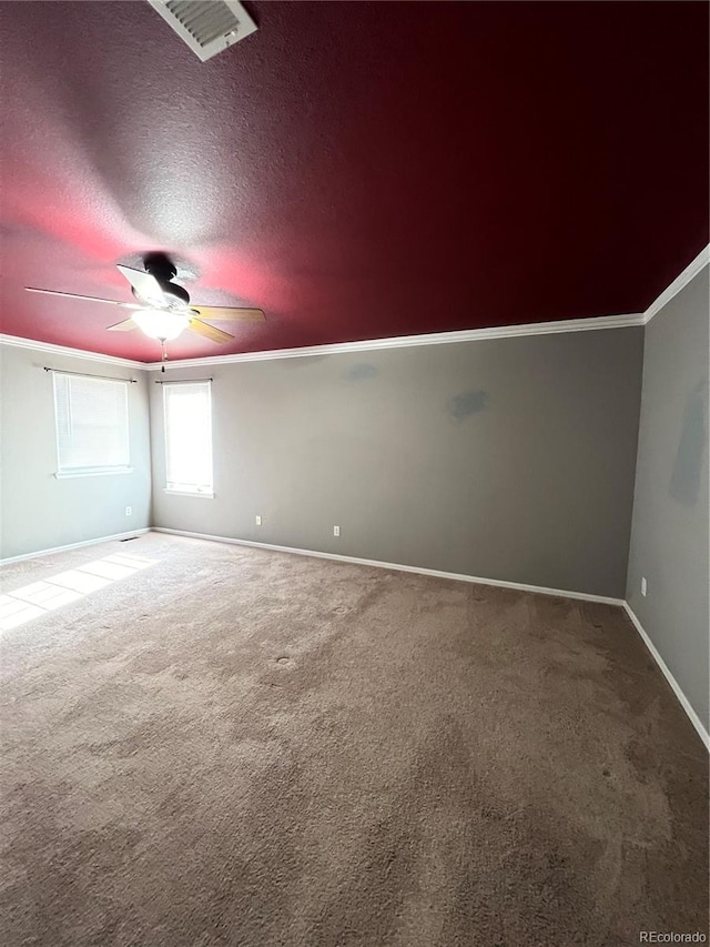 carpeted spare room featuring ceiling fan, a textured ceiling, and ornamental molding