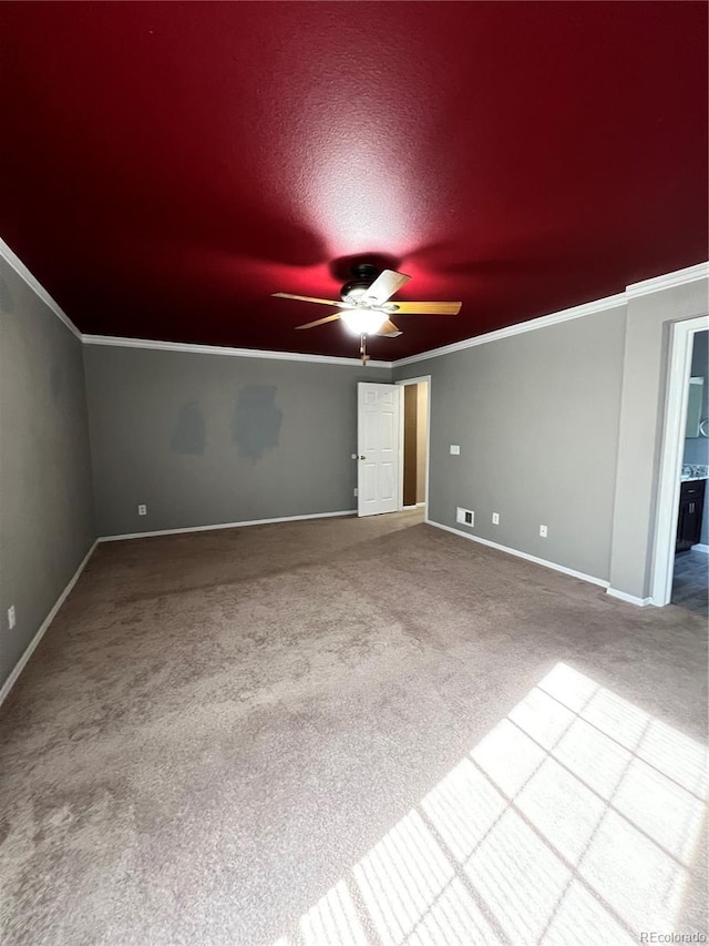 carpeted spare room featuring a textured ceiling, ceiling fan, and crown molding