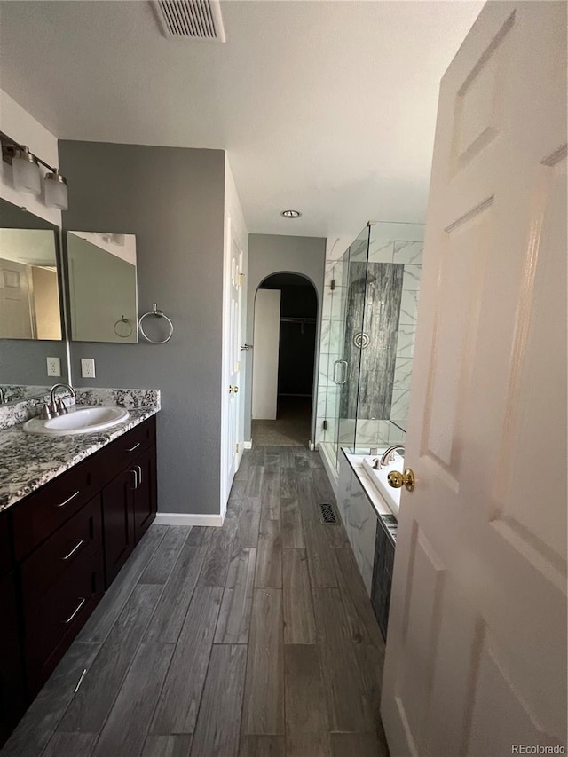 bathroom featuring vanity, wood-type flooring, and separate shower and tub