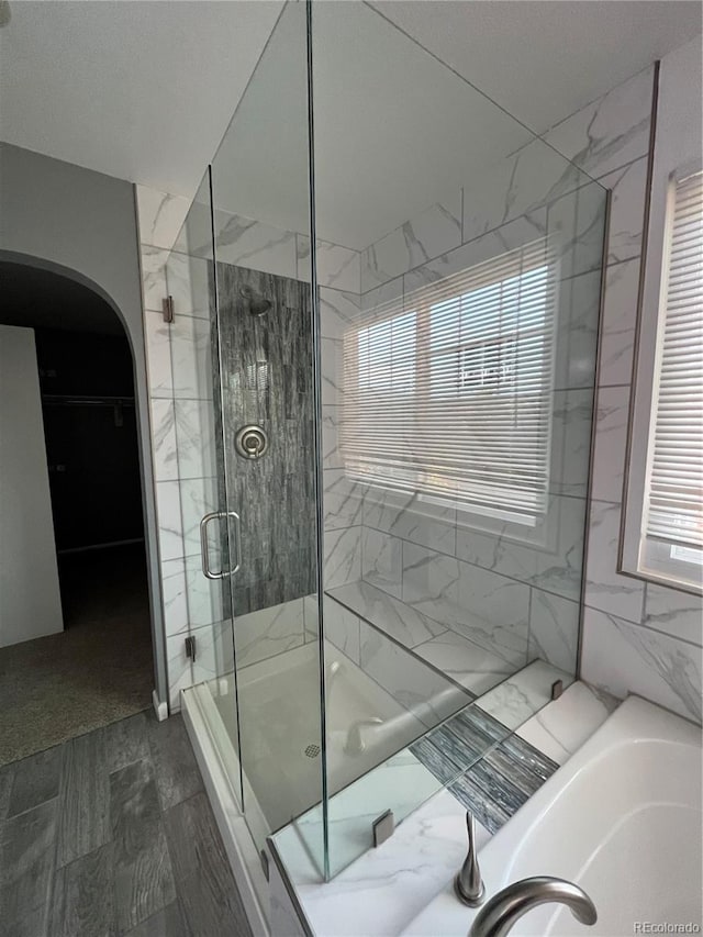 bathroom with tile walls and plus walk in shower