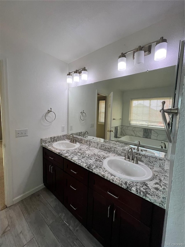 bathroom with a bathtub, vanity, and hardwood / wood-style floors