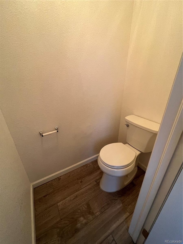 bathroom with toilet and hardwood / wood-style floors