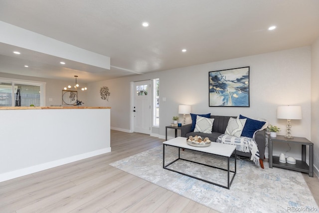 living room with a chandelier and light wood-type flooring