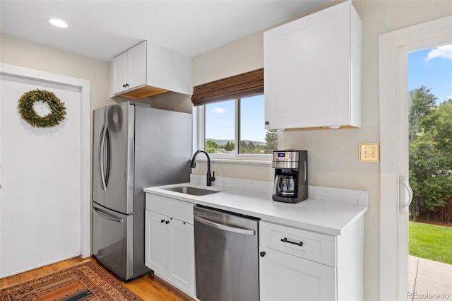 12705 W Chenango Ave, Morrison, CO 80465 - kitchen with appliances with stainless steel finishes, light wood-style floors, white cabinetry, light countertops, and recessed lighting