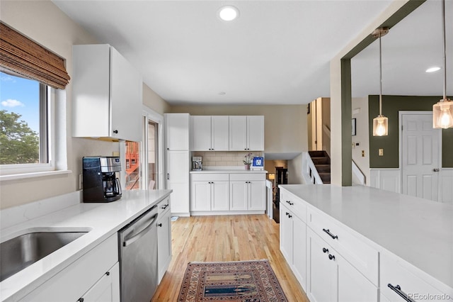 12705 W Chenango Ave, Morrison, CO 80465 - kitchen featuring stainless steel dishwasher, light countertops, backsplash, light wood finished floors, and recessed lighting