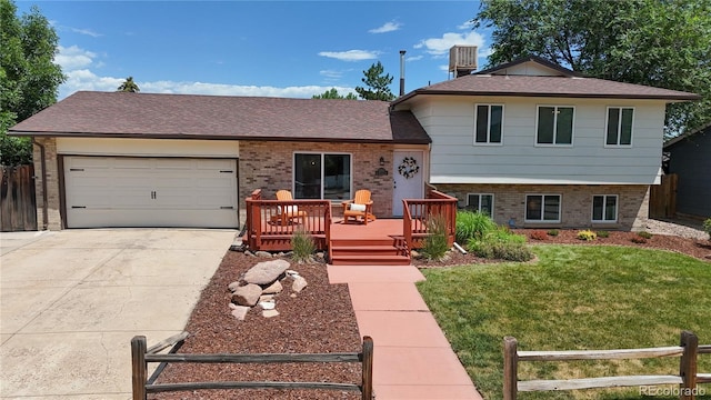 12705 W Chenango Ave, Morrison, CO 80465 - split level home featuring brick siding, concrete driveway, an attached garage, a deck, and a shingled roof