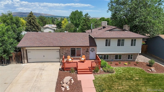 12705 W Chenango Ave, Morrison, CO 80465 - split level home with driveway, a chimney, brick siding, an attached garage, and a deck with mountain view