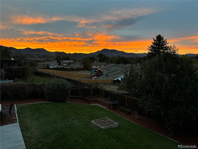 12705 W Chenango Ave, Morrison, CO 80465 - yard at dusk with a mountain view, a vegetable garden, and a fenced backyard