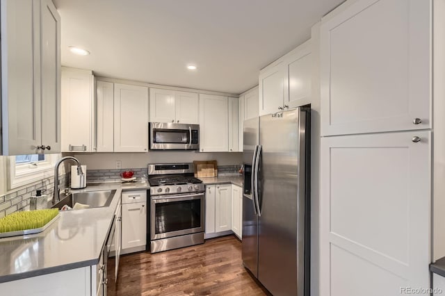 kitchen with stainless steel appliances, a sink, white cabinetry, and recessed lighting