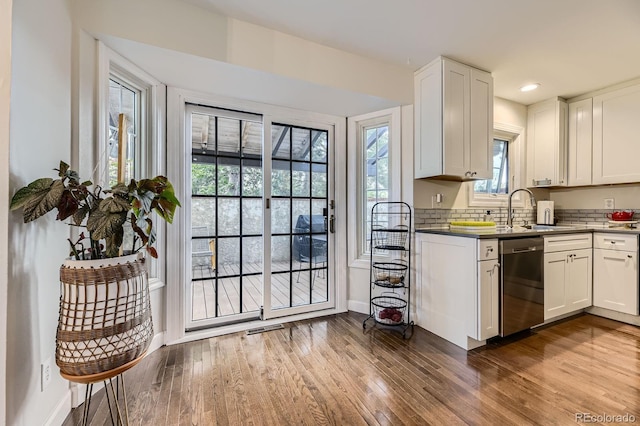 kitchen featuring dishwasher, a sink, dark wood-style flooring, white cabinets, and recessed lighting