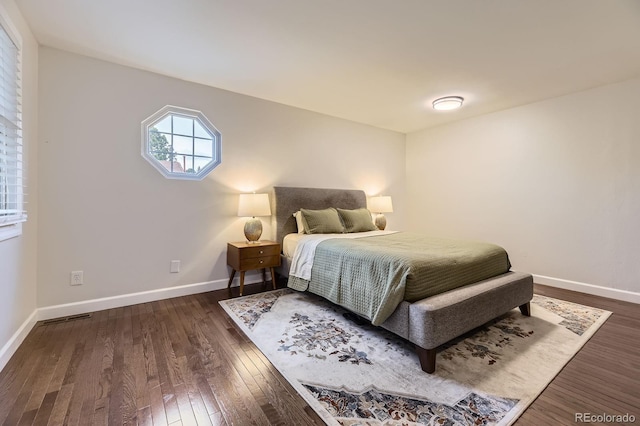 bedroom with dark wood-type flooring and baseboards
