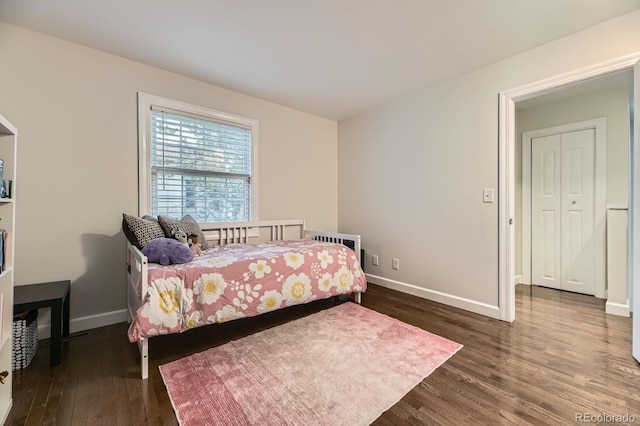 bedroom with dark wood finished floors and baseboards