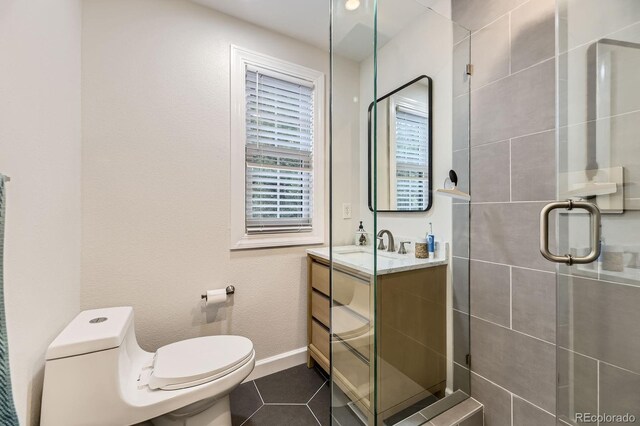 full bathroom featuring a shower stall, toilet, vanity, baseboards, and tile patterned flooring