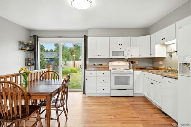 2011 S Vallejo St, Denver, CO 80223 - kitchen with white appliances, light wood finished floors, and white cabinetry
