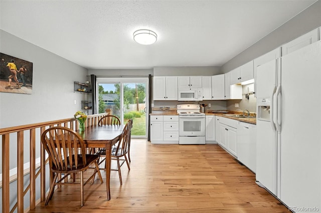 2011 S Vallejo St, Denver, CO 80223 - kitchen with white appliances, light wood-style flooring, and white cabinetry