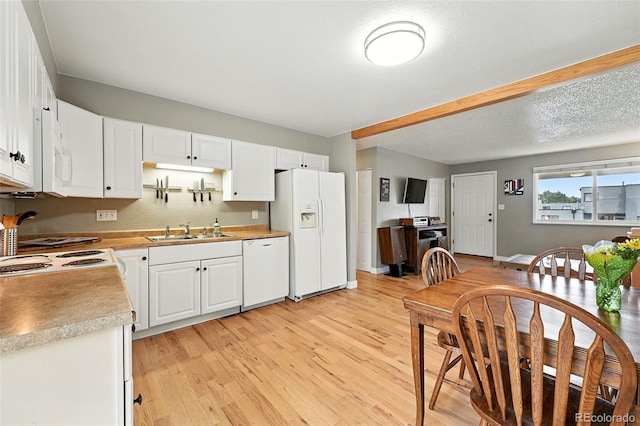 2011 S Vallejo St, Denver, CO 80223 - kitchen featuring white appliances, light wood-style floors, white cabinetry, and light countertops