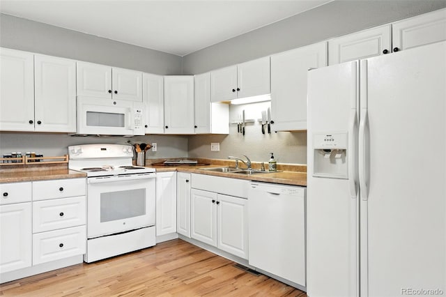 2011 S Vallejo St, Denver, CO 80223 - kitchen featuring white appliances, light wood-type flooring, white cabinetry, and light countertops