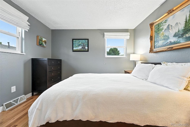 2011 S Vallejo St, Denver, CO 80223 - bedroom featuring wood finished floors and a textured ceiling
