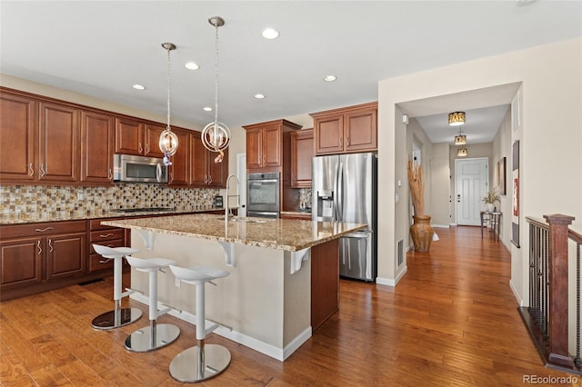 3278 Ghost Dance Dr, Castle Rock, CO 80108 - kitchen featuring stainless steel appliances, dark wood-type flooring, decorative backsplash, a breakfast bar, and recessed lighting