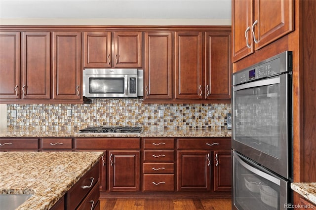 3278 Ghost Dance Dr, Castle Rock, CO 80108 - kitchen featuring stainless steel appliances, light stone countertops, dark wood-style floors, and tasteful backsplash