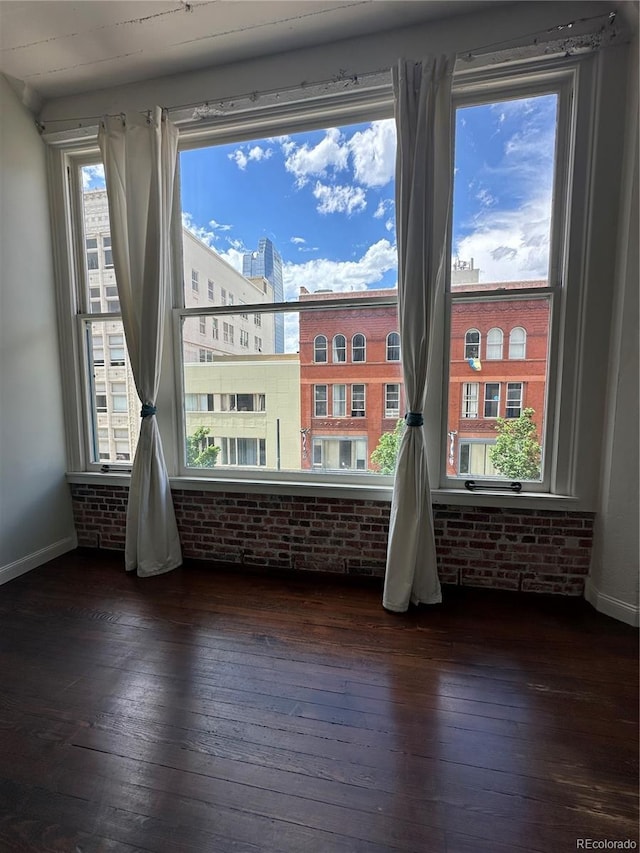720 16th St Unit 306, Denver, CO 80202 - spare room featuring dark wood-style flooring, brick wall, and baseboards