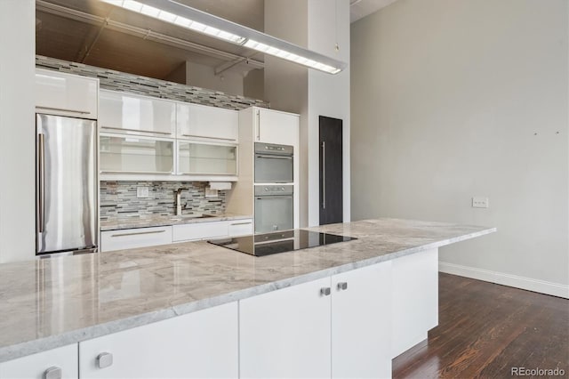 720 16th St Unit 306, Denver, CO 80202 - kitchen featuring stainless steel appliances, a sink, decorative backsplash, dark wood-type flooring, and white cabinets