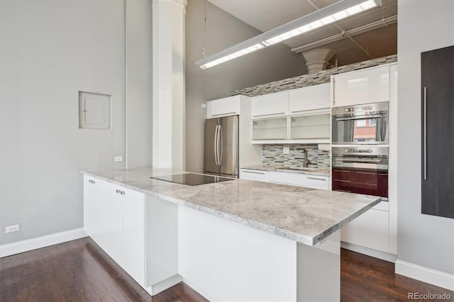 720 16th St Unit 306, Denver, CO 80202 - kitchen with appliances with stainless steel finishes, modern cabinets, a peninsula, dark wood-type flooring, and baseboards