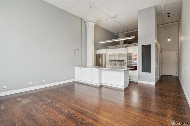 720 16th St Unit 306, Denver, CO 80202 - kitchen with a towering ceiling, stainless steel appliances, a peninsula, ornate columns, and dark wood finished floors