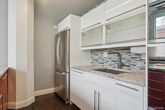 720 16th St Unit 306, Denver, CO 80202 - kitchen featuring freestanding refrigerator, baseboards, a sink, tasteful backsplash, and dark wood-style flooring