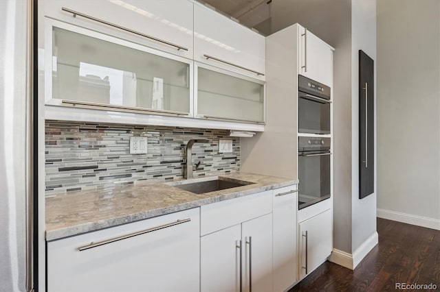 720 16th St Unit 306, Denver, CO 80202 - kitchen with a sink, modern cabinets, dark wood-style floors, decorative backsplash, and baseboards