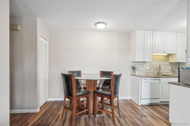 dining room with dark hardwood / wood-style flooring and sink