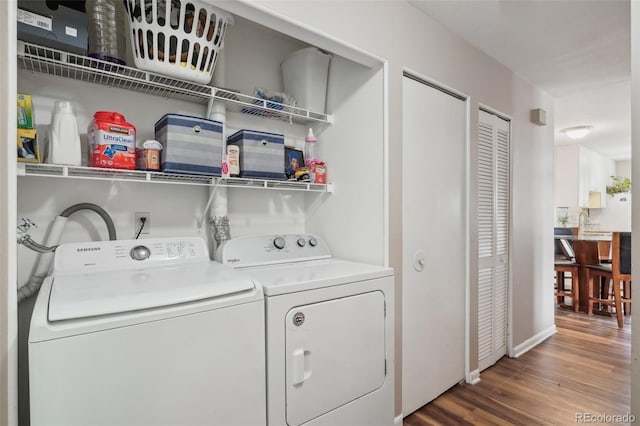 laundry room with washer and clothes dryer and wood-type flooring