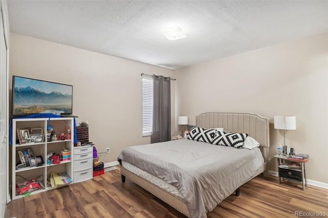 bedroom featuring wood-type flooring and a textured ceiling