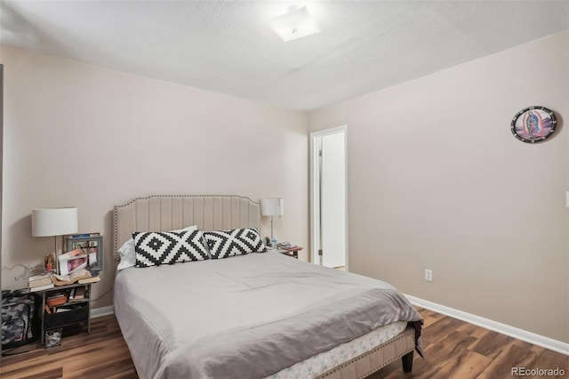 bedroom with dark hardwood / wood-style flooring and a textured ceiling