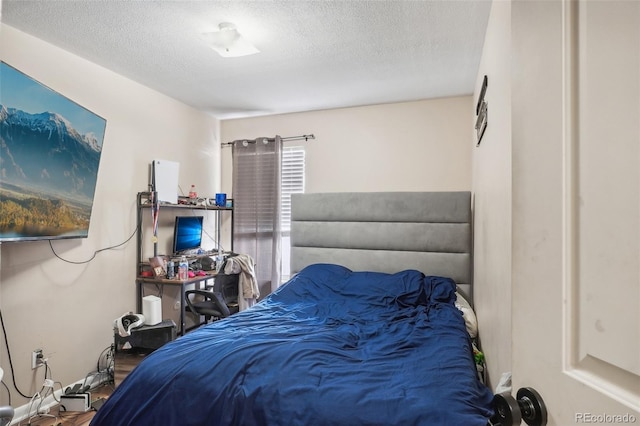 bedroom featuring wood-type flooring and a textured ceiling