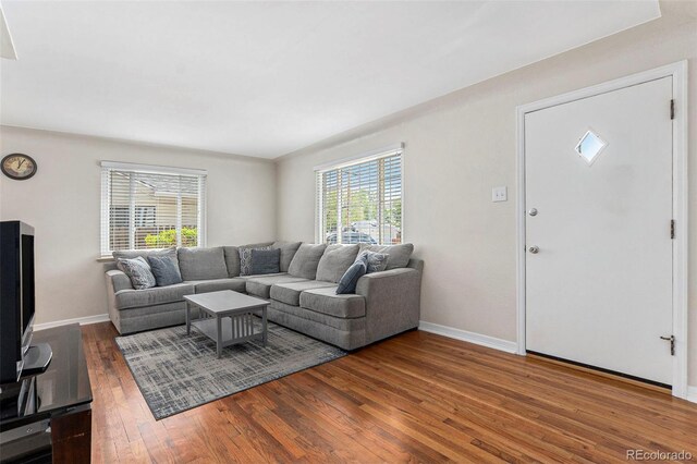 living area with wood-type flooring and baseboards