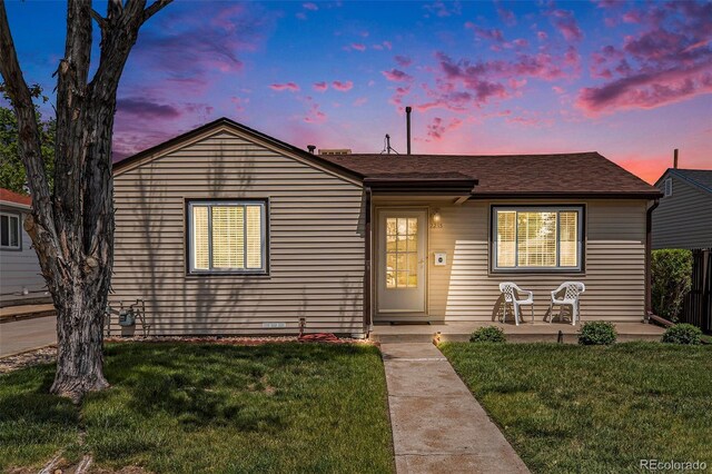 view of front of home featuring a front yard and a shingled roof