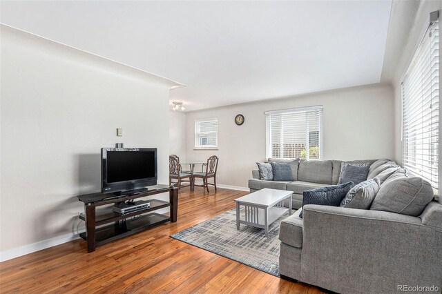 living room with wood finished floors, baseboards, and a chandelier