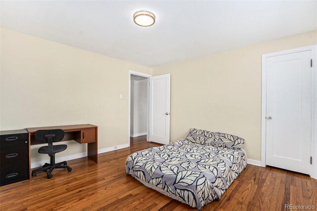 bedroom featuring wood finished floors and baseboards