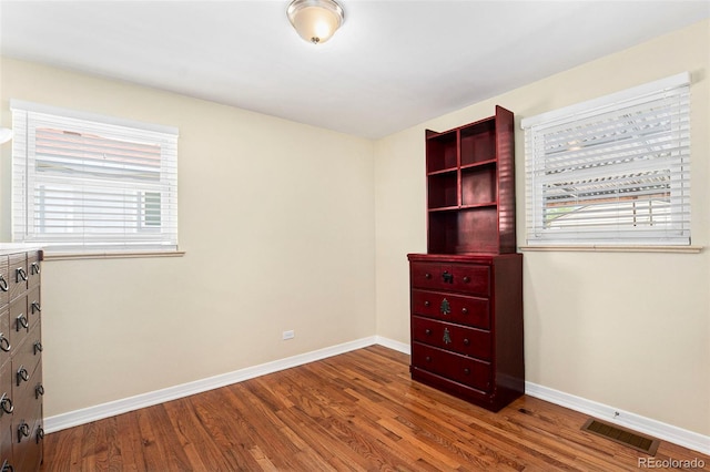 unfurnished bedroom featuring wood finished floors and baseboards