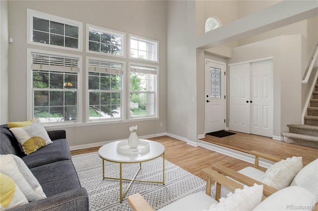 8652 Aberdeen Cir, Highlands Ranch, CO 80130 - living area with stairs, baseboards, light wood-style floors, and a towering ceiling