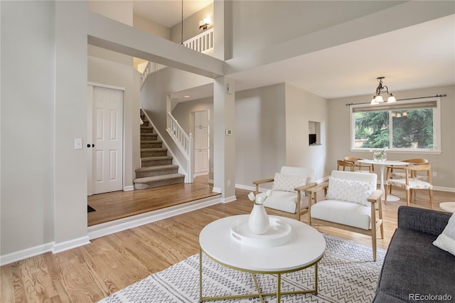 8652 Aberdeen Cir, Highlands Ranch, CO 80130 - living room featuring stairway, light wood-style flooring, baseboards, and a chandelier