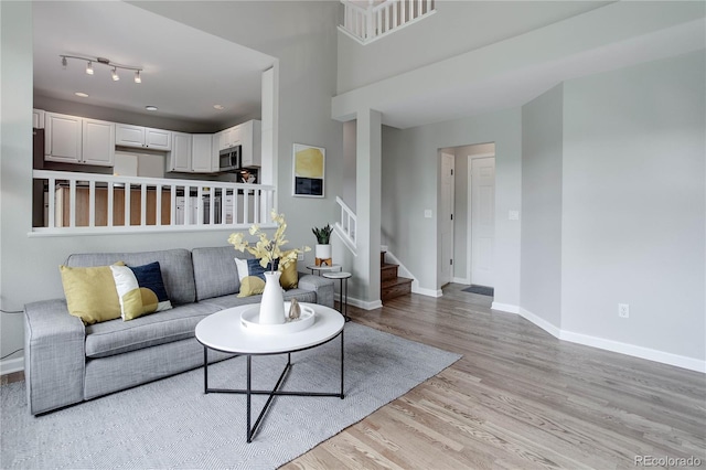 8652 Aberdeen Cir, Highlands Ranch, CO 80130 - living area featuring light wood finished floors, stairway, and baseboards