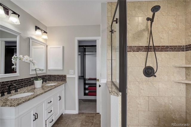 8652 Aberdeen Cir, Highlands Ranch, CO 80130 - full bathroom featuring double vanity, tiled shower, baseboards, and decorative backsplash