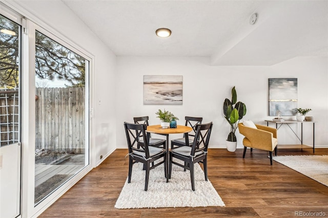 dining area featuring baseboards and dark wood-type flooring