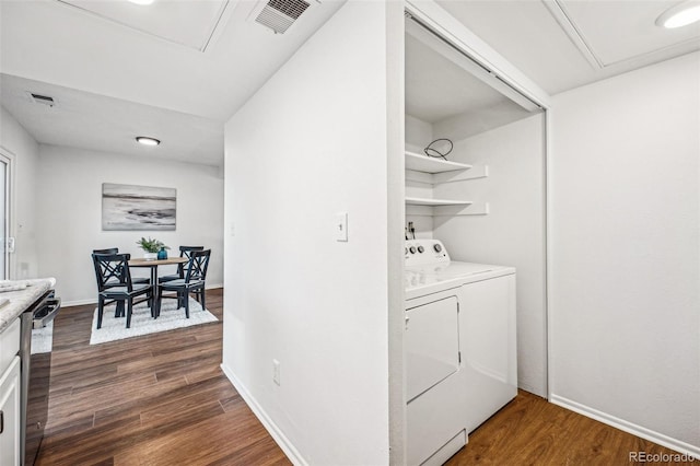 laundry room with laundry area, dark wood-type flooring, visible vents, baseboards, and washing machine and clothes dryer