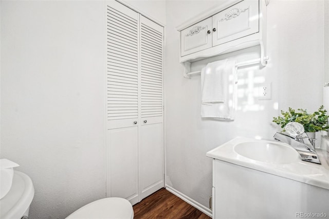 bathroom with wood finished floors, vanity, and toilet