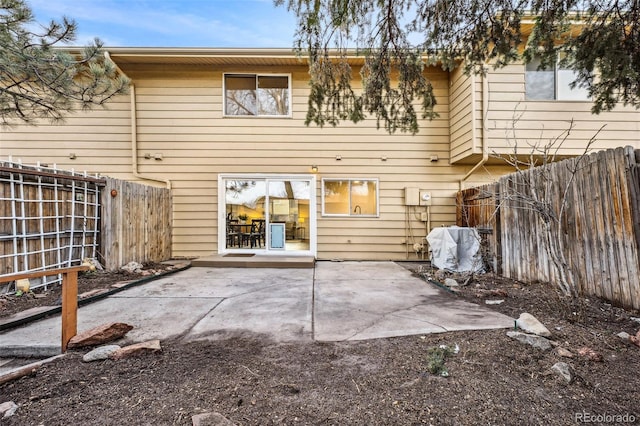 rear view of house with a patio area and fence