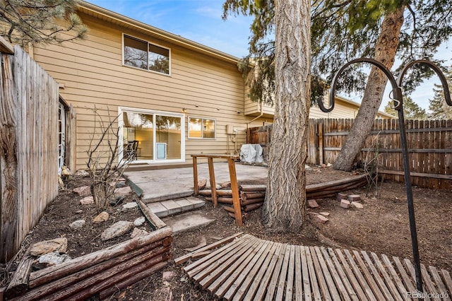 back of property featuring fence and a patio